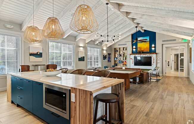 A kitchen with a blue wall and wooden floors.