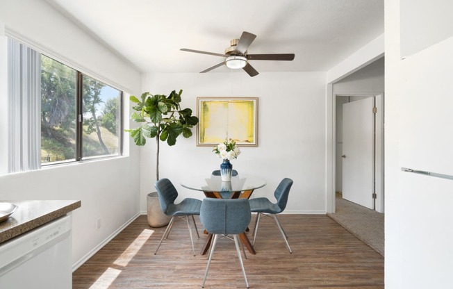 a dining room with a table and chairs and a ceiling fan