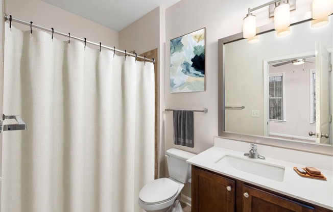 a bathroom with a white shower curtain and a sink and a toilet