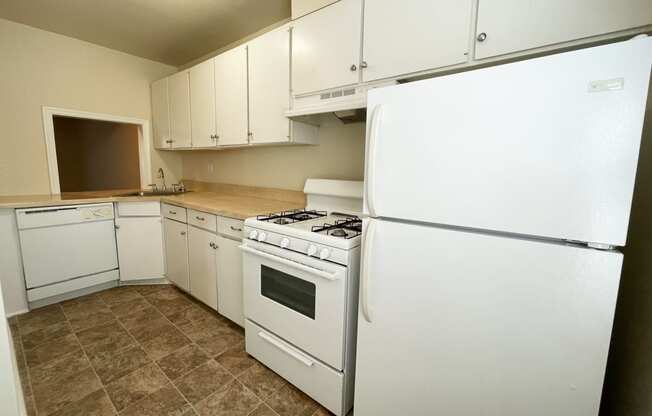 a kitchen with white appliances and white cabinets