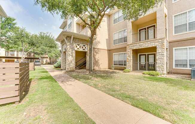 Apartment building with a tree in front.