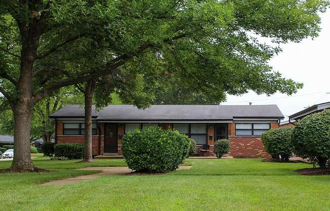 a house with a yard and trees in front of it