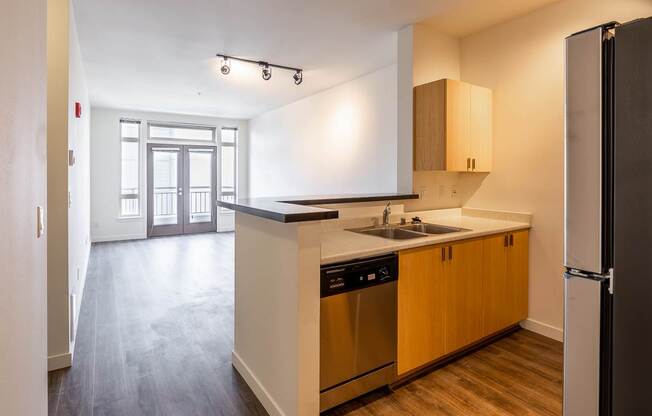 A kitchen with wooden cabinets and a black fridge.