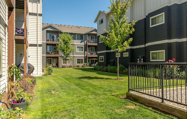 A black and white apartment building with a green lawn in front at Forestplace Apartment Homes, Forest Grove, OR, 97116