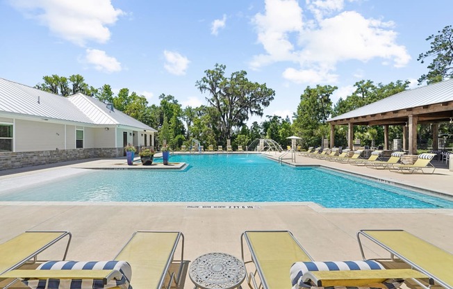 Sparkling swimming pool with lounge chairs at Capital Grand Apartments in Tallahassee, FL