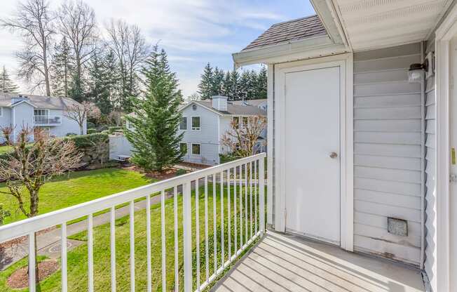 the view of the yard from the balcony of a home with a white door  at Springfield, Renton, WA, 98055