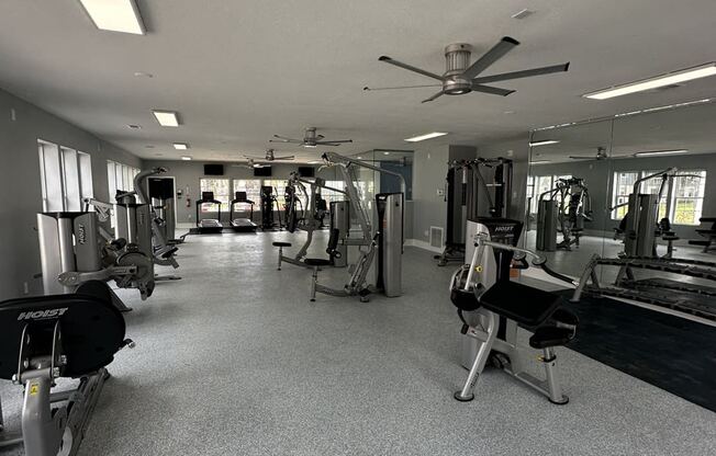 a gym with weights machines and a ceiling fan