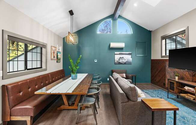 A living room with a brown leather couch and a wooden table.