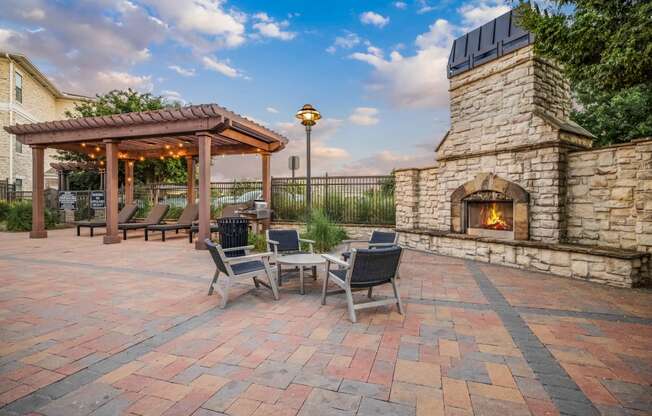 a patio with a stone fireplace and a table with chairs