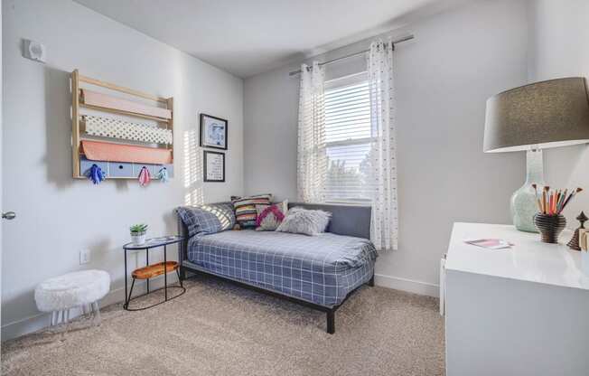 a bedroom with a bed and a desk and a window