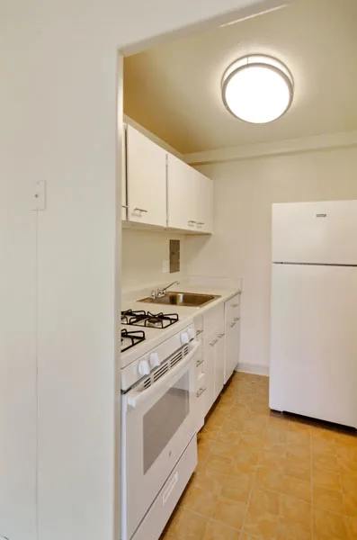 Studio Kitchen with White Cabinets
