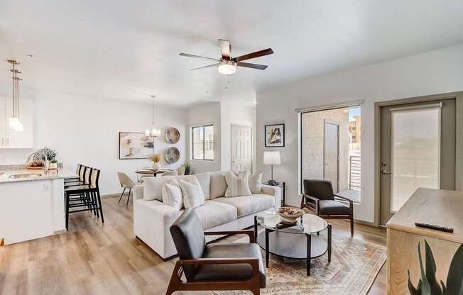 A living room with a white couch, a coffee table, and a ceiling fan.