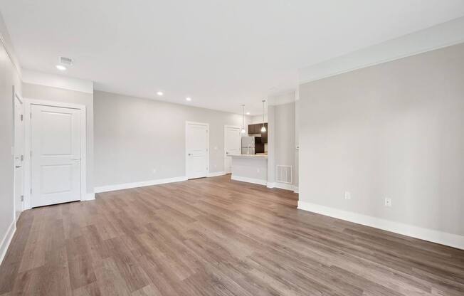 A room with wooden flooring and white walls.