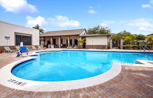 A large outdoor swimming pool with a red brick border.