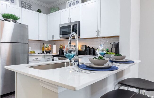 a kitchen with white cabinets and a sink and a counter top