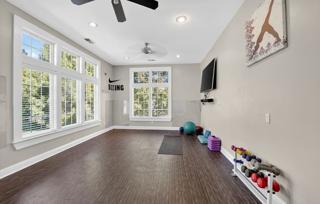 Yoga room with large windows, ceiling fans, mat and free weight