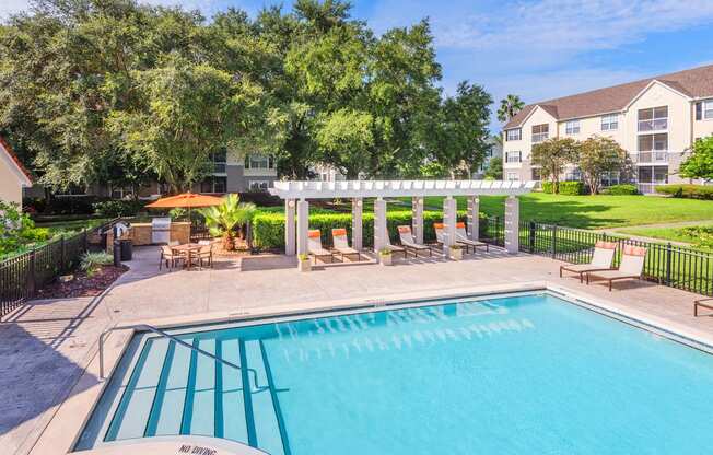 The Colony at Deerwood Apartments - Resort-style pool with pergola and BBQ