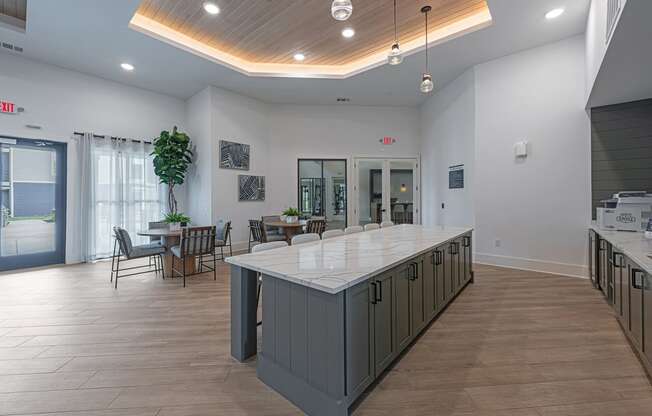 a large kitchen with a center island and a dining room with tables and chairs