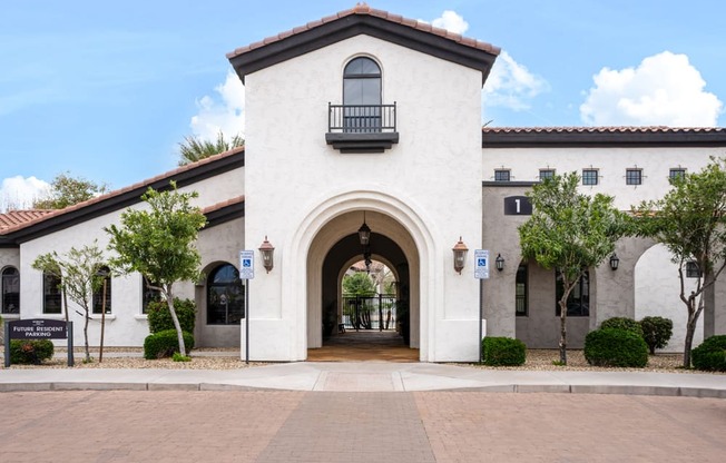 a white building with an arched doorway and a courtyard