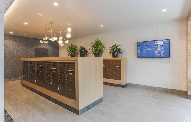A reception area with a wooden counter and a TV screen on the wall.