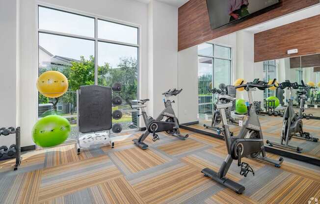 A gym with exercise equipment and a green exercise ball.