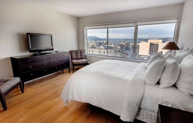 a bedroom with a large window and a large bed