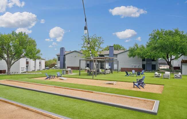 a park with a playground and picnic tables in front of a building