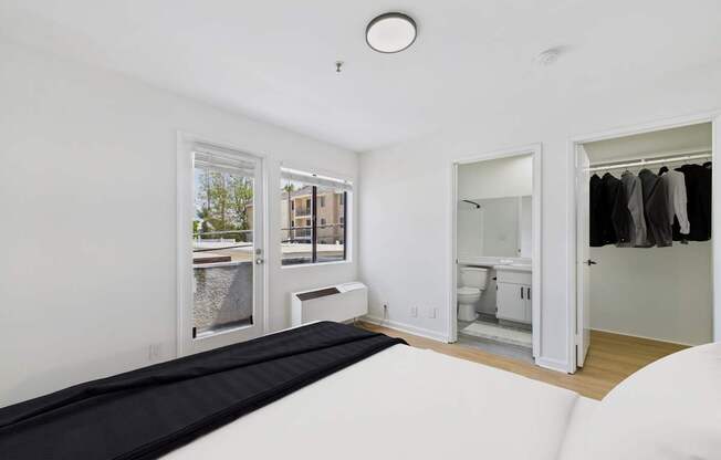 A white room with a black mattress and a window.