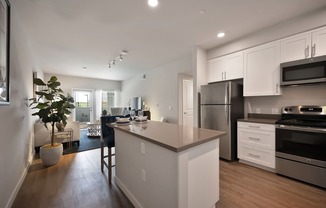 A modern kitchen with white cabinets and stainless steel appliances.