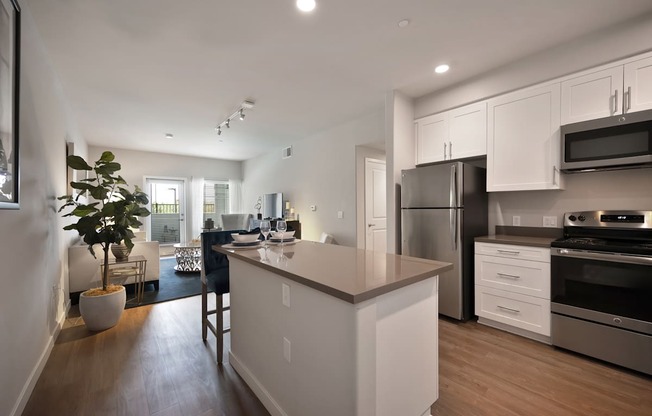 A modern kitchen with white cabinets and stainless steel appliances.