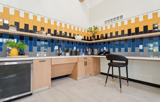 A kitchen with a black chair and wooden cabinets.