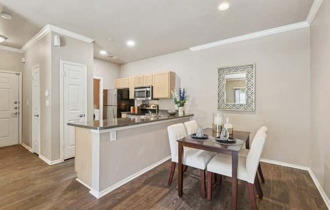 a dining room and kitchen with a table and chairs