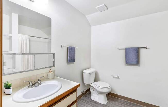 A bathroom with a white toilet and a white sink at Shiloh Glen Apartments in Billings, MT.