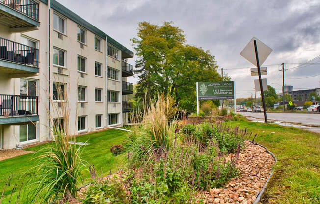 A green sign is in front of a building.