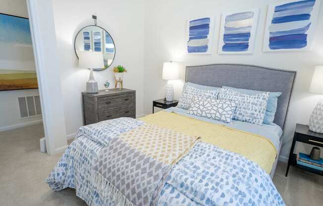 A bedroom with a bed covered in a blue and yellow patterned comforter.