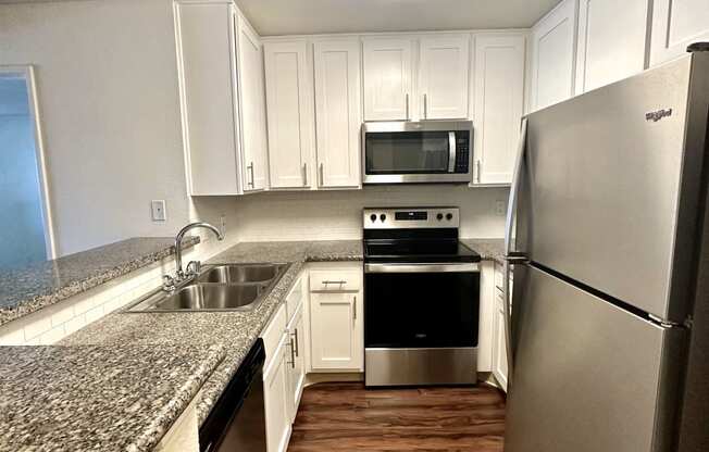 a kitchen with granite counter tops and stainless steel appliances