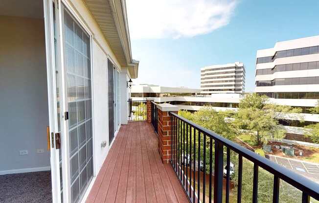 A balcony with a black railing and a brick pillar.