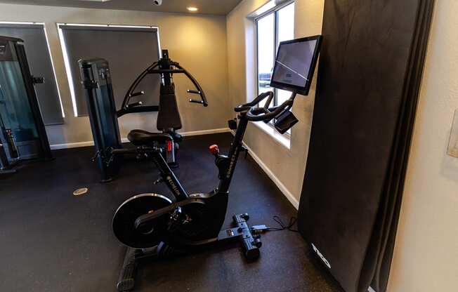 a home gym with an exercise bike and a flat screen tv