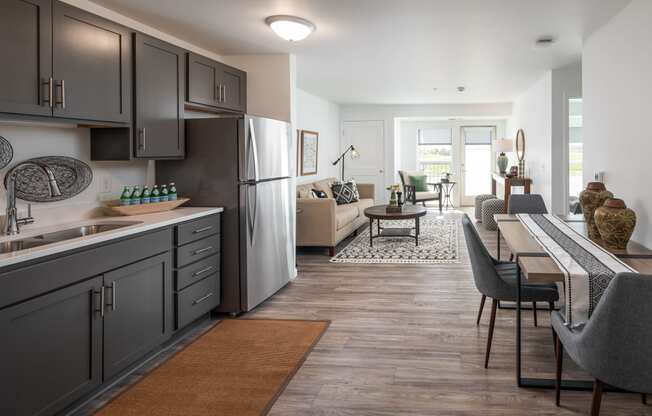 a kitchen and living room with a table and chairs and a refrigerator