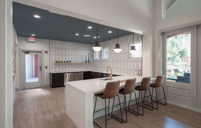 a kitchen with a white counter and chairs