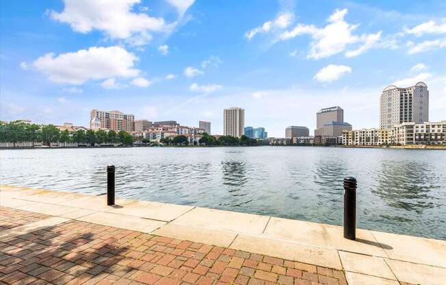 A cityscape with buildings and a body of water in the foreground.