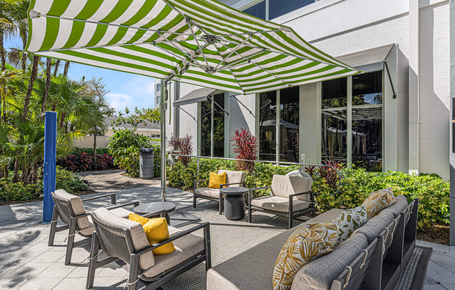 a patio with chairs and umbrellas in front of a building