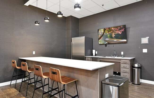 a kitchen with a long counter and chairs