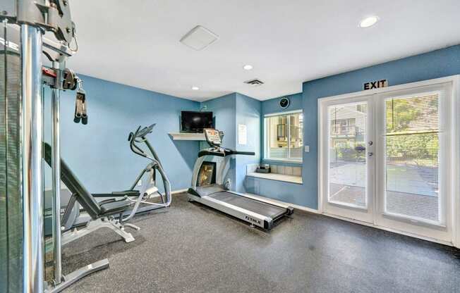 the gym has plenty of cardio equipment and a window