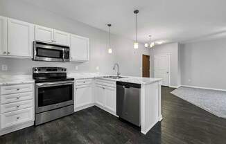 an empty kitchen with white cabinets and stainless steel appliances