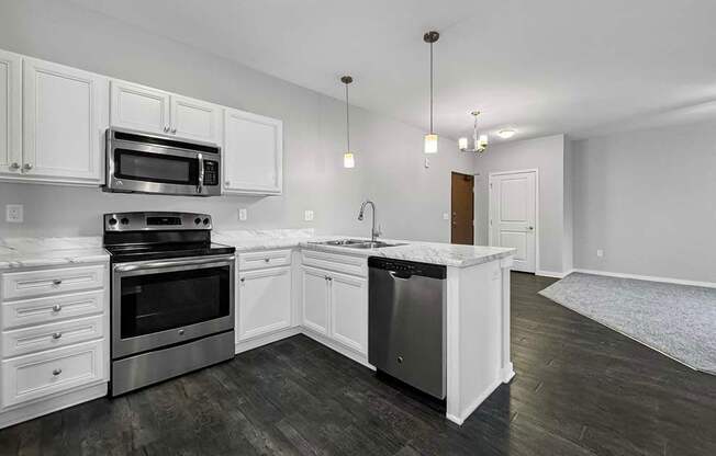 an empty kitchen with white cabinets and stainless steel appliances