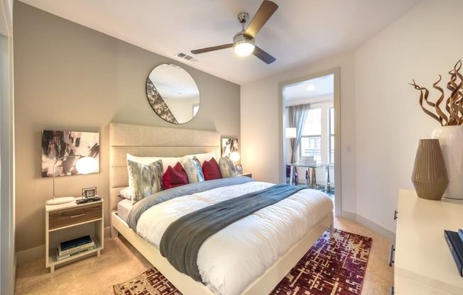 Bedroom with wood flooring and a bed facing the entry doorway into the apartment.