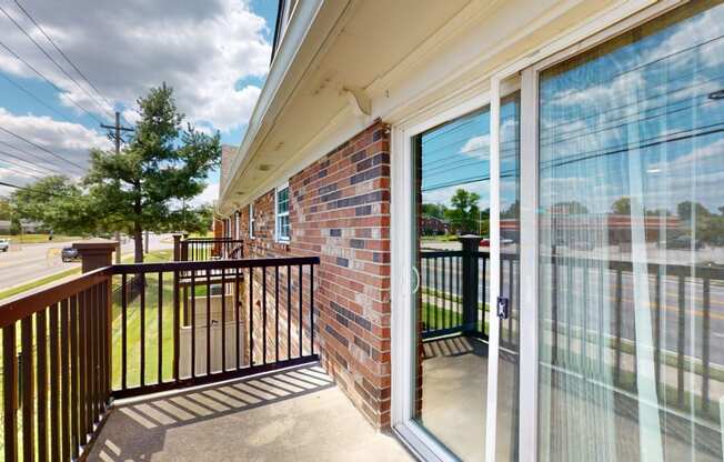 the balcony has a view of the parking lot and the street