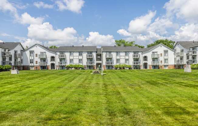 A row of white apartment buildings with green lawns in front
