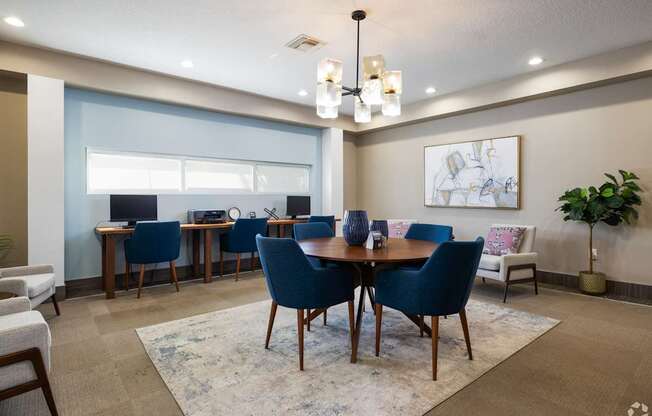 A dining room with a table surrounded by chairs and a rug on the floor.
